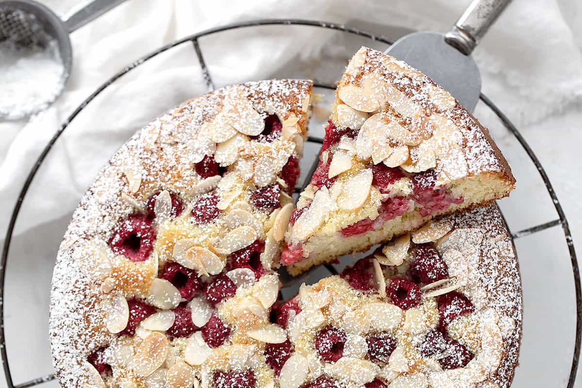 raspberry buttermilk cake sliced on cooling rack