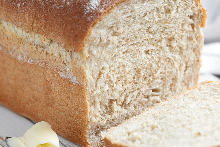 honey whole wheat bread sliced on cutting board