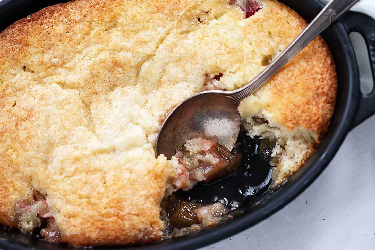 rhubarb cobbler in baking dish with spoon