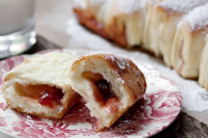 raspberry jam filled pull apart bread with a piece on a small plate