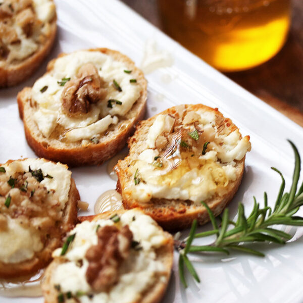 goat cheese crostini with walnuts and honey on serving platter