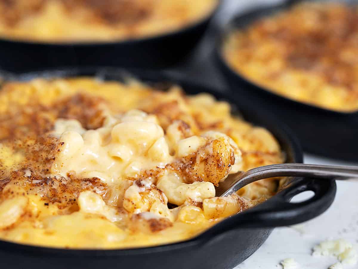 creamy mac and cheese in cast iron skillets with fork