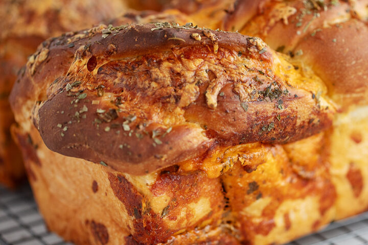 Homemade cheese bread on a cooling rack.