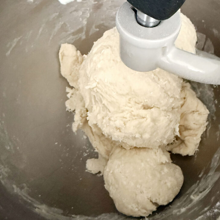 Mixing together the dough ingredients in a mixing bowl.