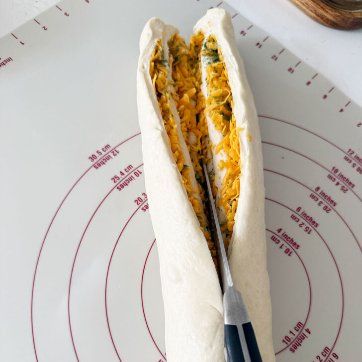 Slicing the filled dough in half lengthwise.