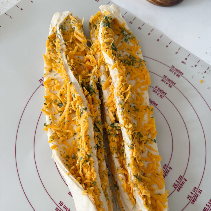 Filled cheese bread dough after slicing in half.