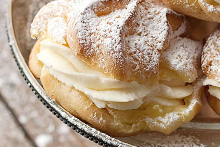 cannoli cream filled cream puffs on silver stand