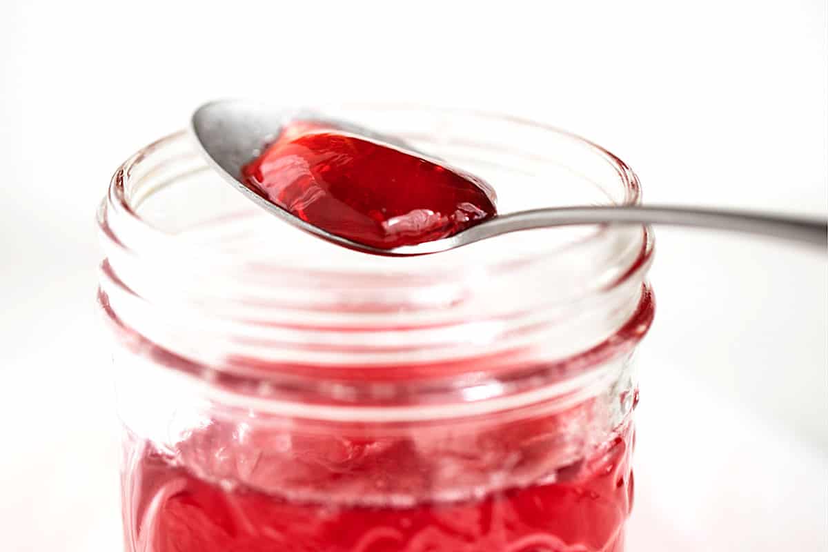 homemade crab apple jelly in jar with some on spoon