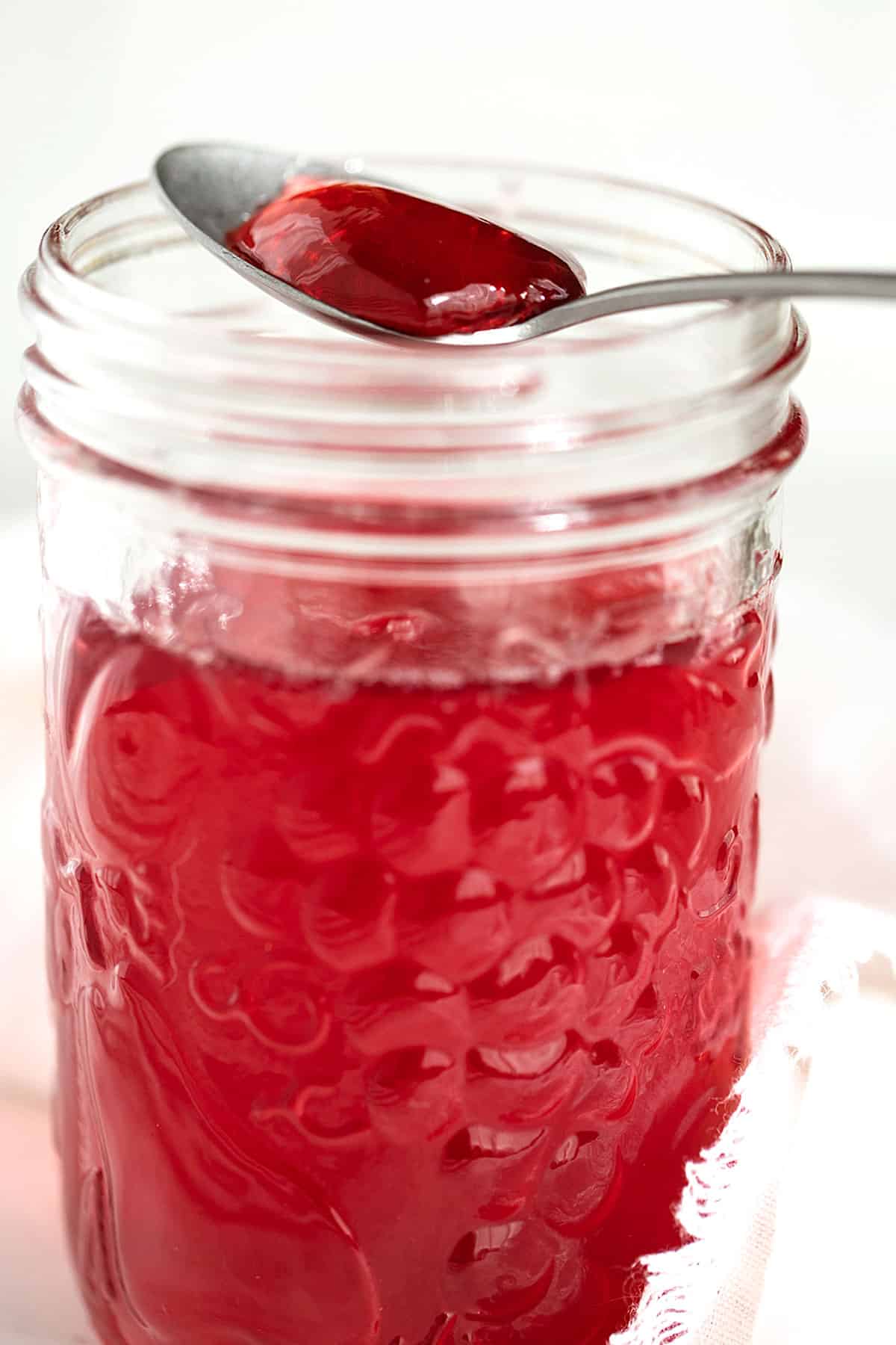 homemade crab apple jelly in jar with some on spoon
