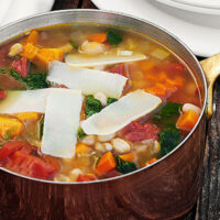harvest vegetable soup in copper saucepan