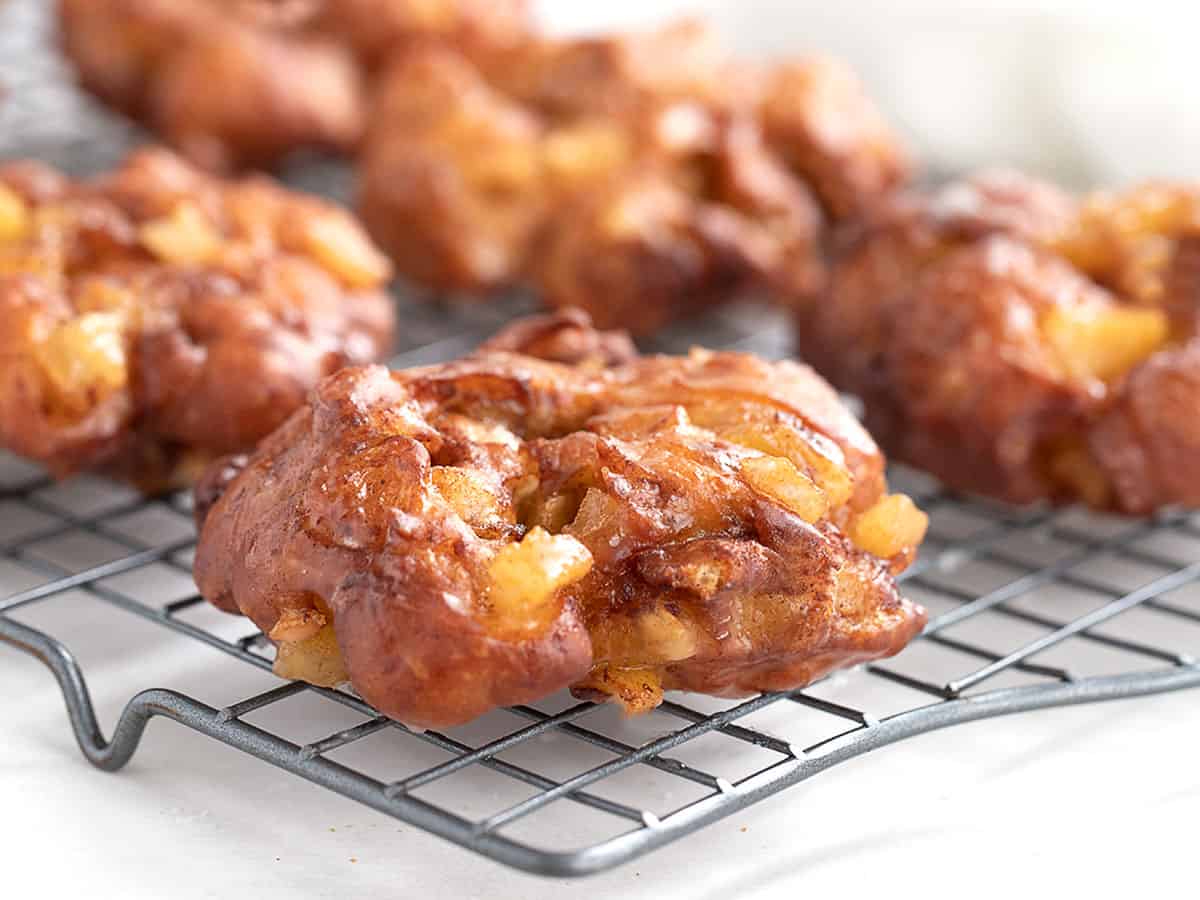 apple fritter yeast doughnuts on cooling rack.