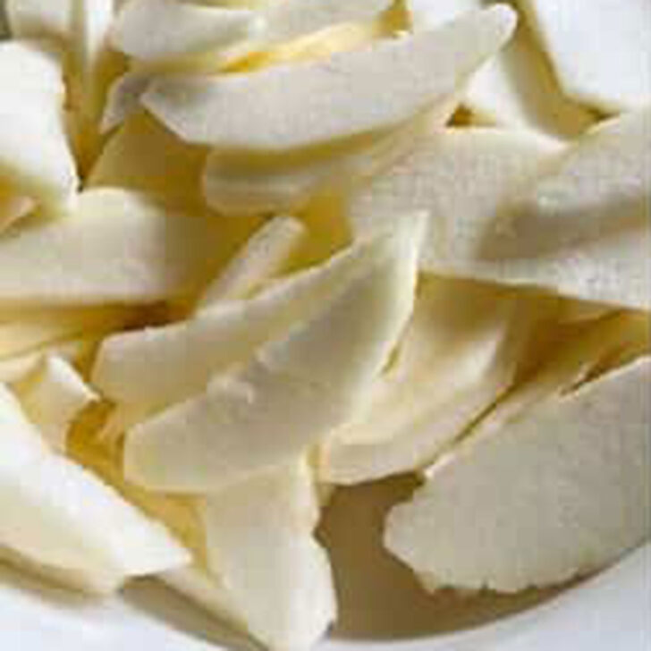 Peeled and cored apples sliced in a bowl.