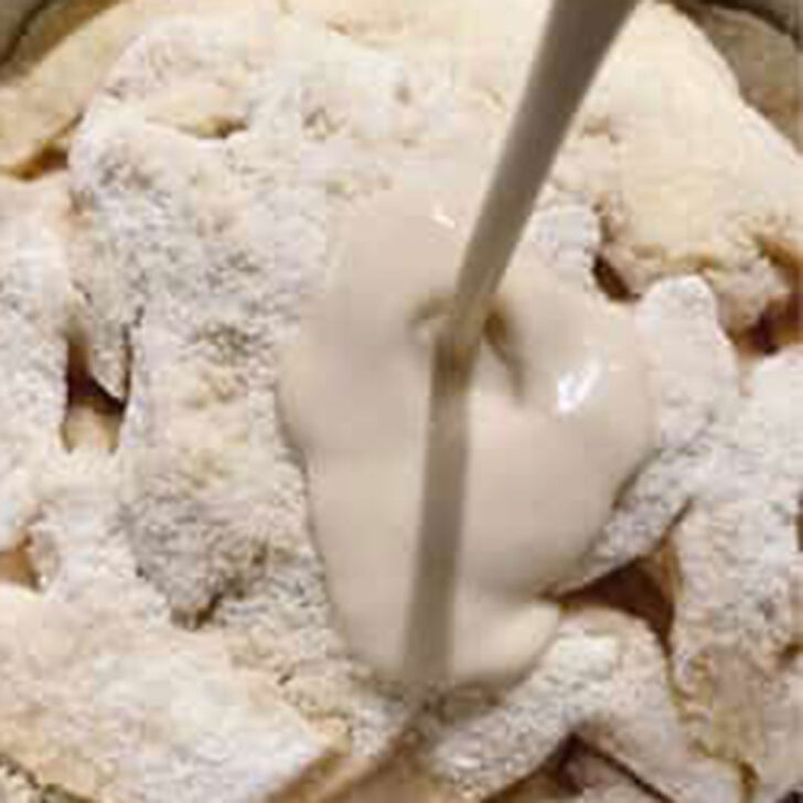 Pouring the cream mixture over the apples and crust.