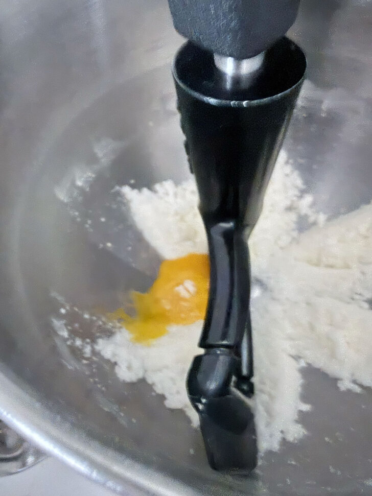Egg yolk added to the mixer bowl.