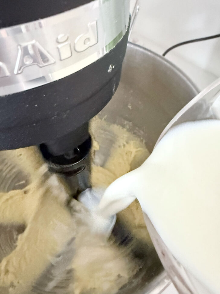 Adding milk to the batter.