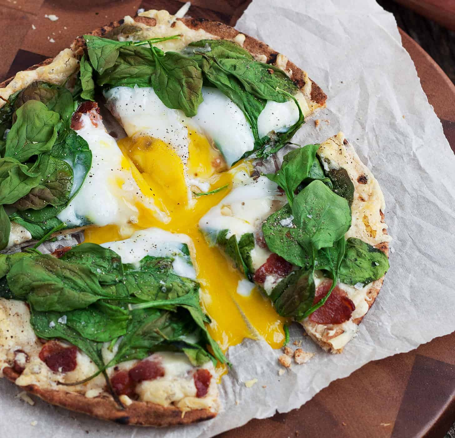 breakfast pita pizza sliced on parchment paper
