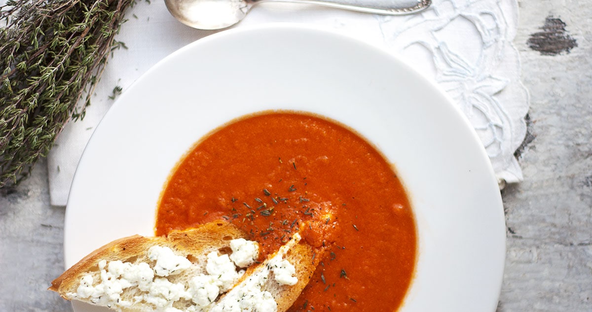 tomato soup in white bowl with cheese toasts
