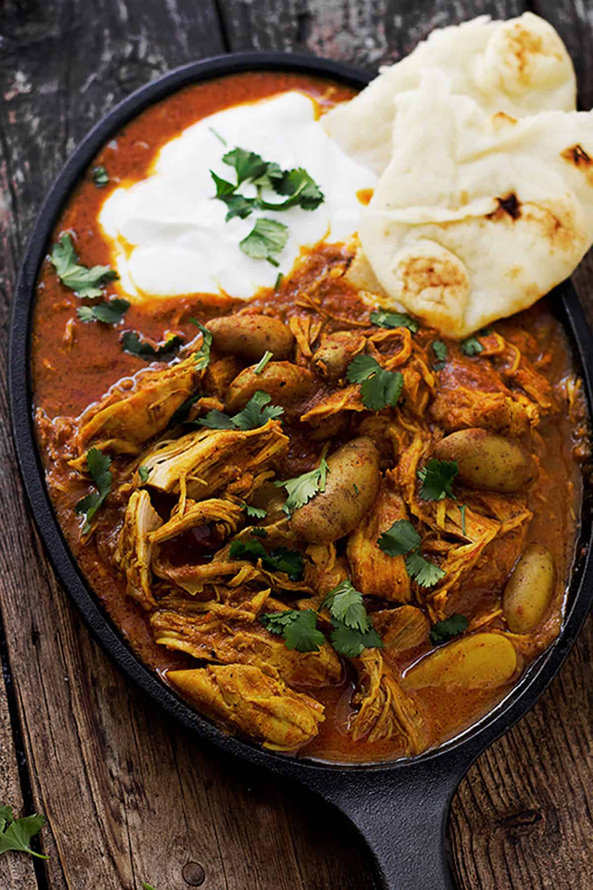 Indian spiced chicken with naan on cast iron dish