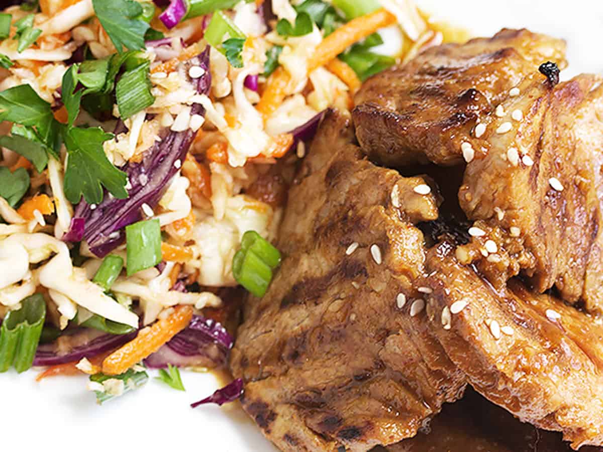 spicy Korean pork with Asian slaw on white plate