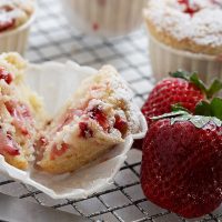 strawberry shortcake muffins on cooling rack with strawberries