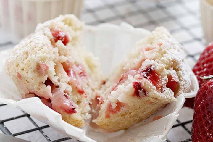 strawberry shortcake muffins on cooling rack with strawberries