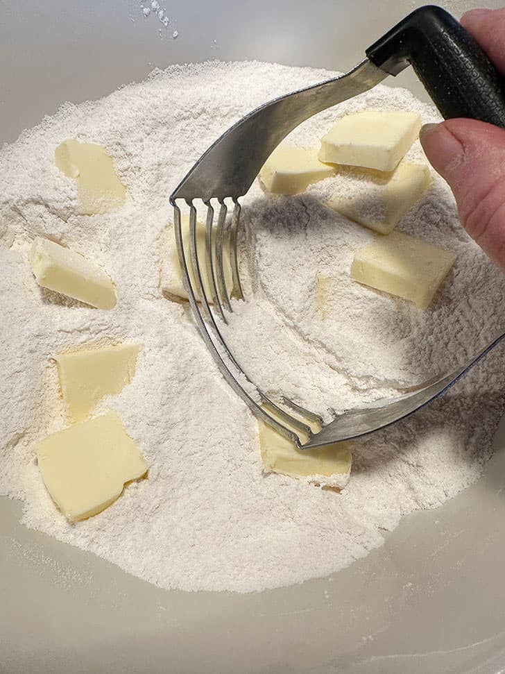 cutting butter cubes into dry ingredients