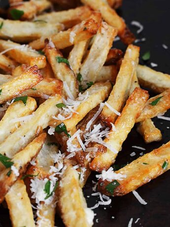 fries with garlic aioli and parmesan cheese on baking sheet