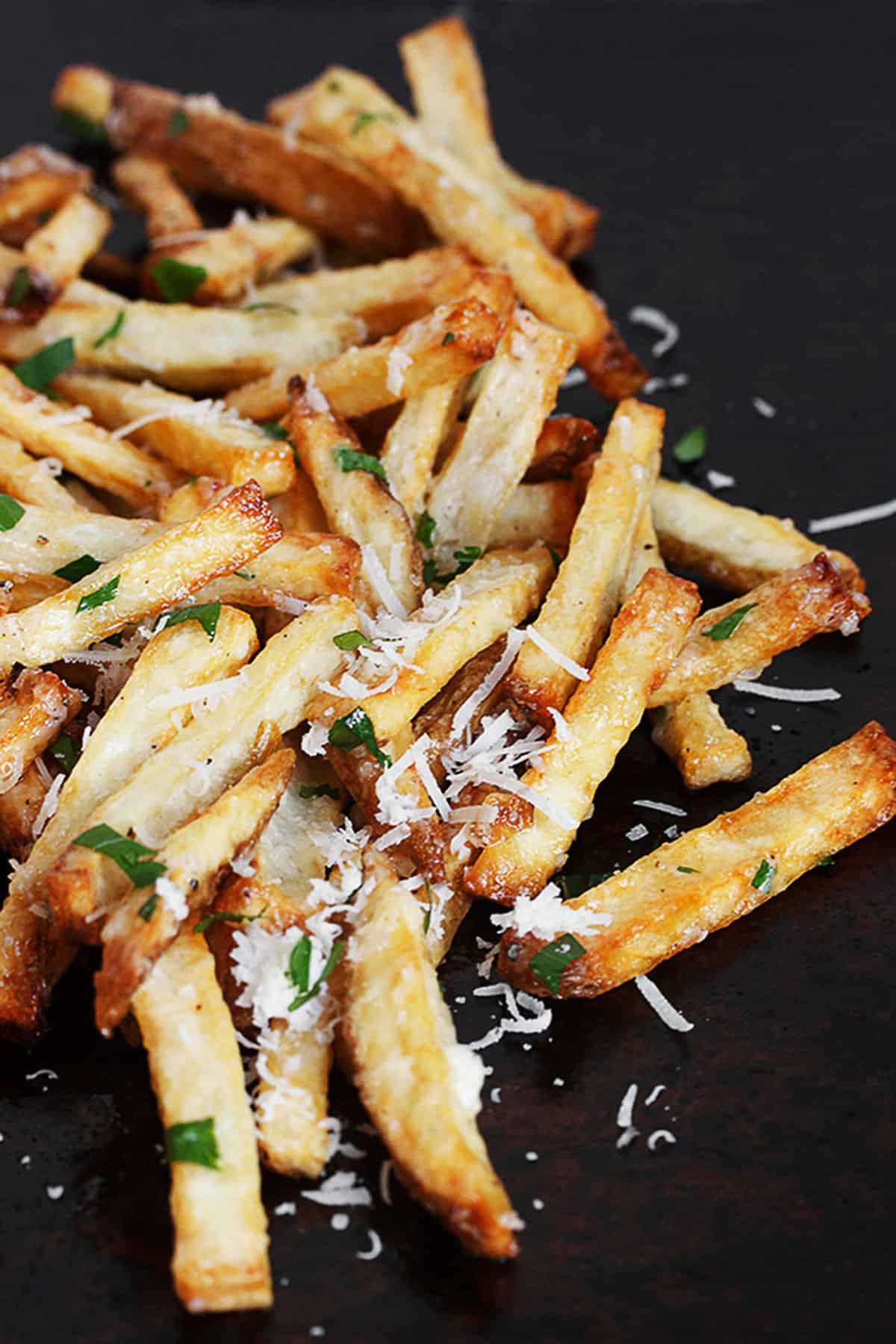 fries with garlic aioli and parmesan cheese on baking sheet