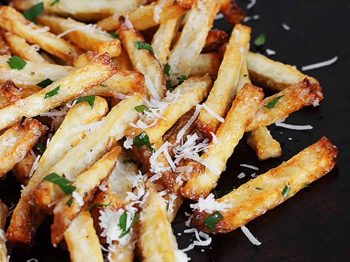 fries with garlic aioli and parmesan cheese on baking sheet