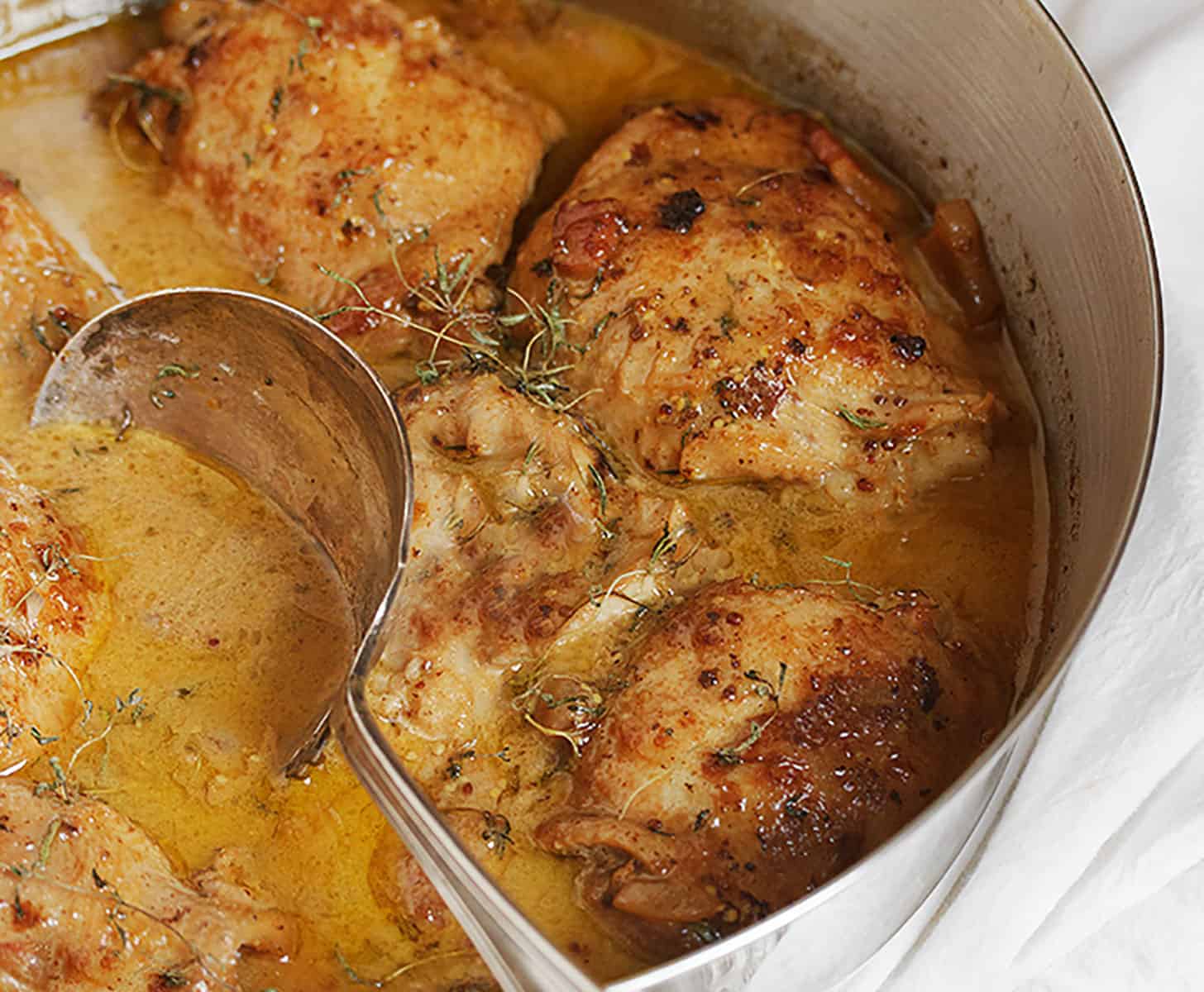 mustard chicken in skillet with spoon