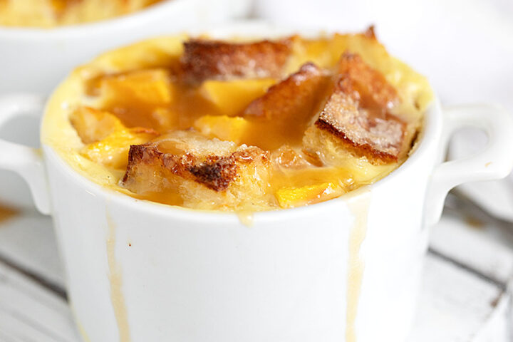 peach bread pudding with brown sugar sauce in ramekins