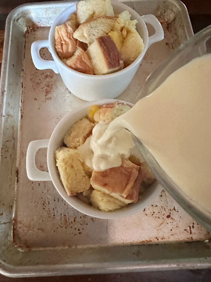 pouring the custard mixture over the bread and peaches