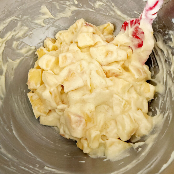 Diced peaches added to the batter in the mixing bowl.