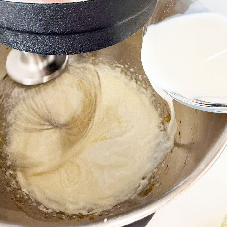 Adding the milk to the whipped eggs and sugar in the mixing bowl.