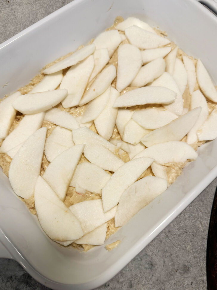 batter and apple slices in baking dish