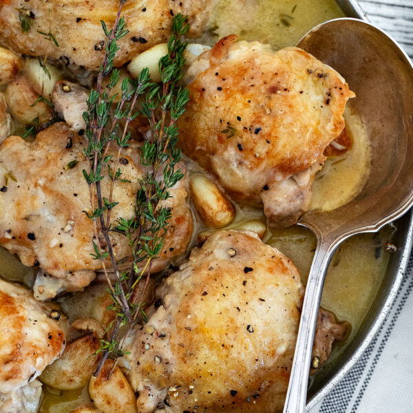 chicken with garlic gravy on serving platter with spoon