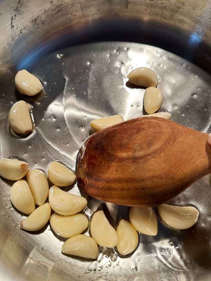 Garlic cloves added to hot skillet.