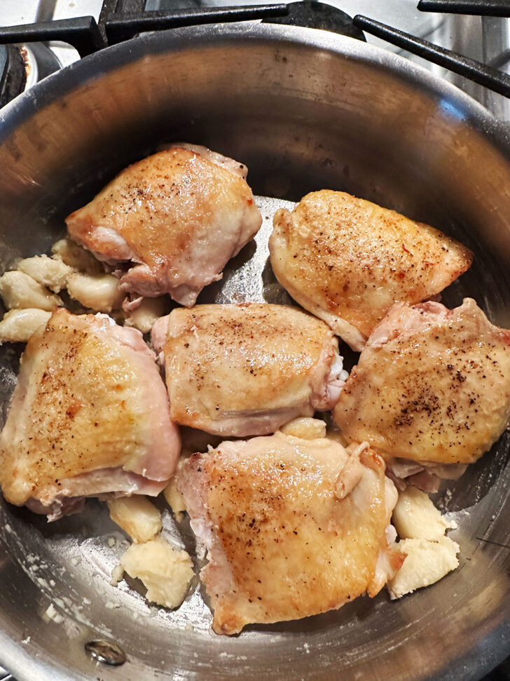 Chicken thighs returned to the pan.