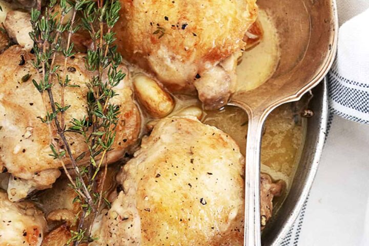 chicken with garlic gravy in serving dish with spoon
