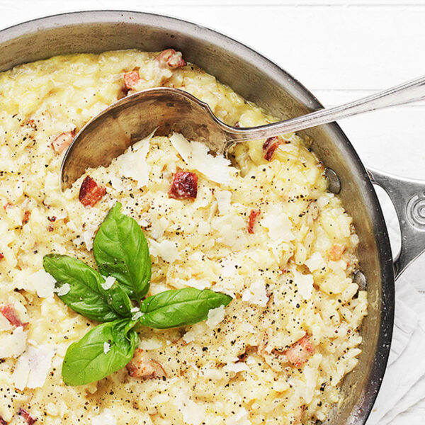 baked carbonara risotto in skillet with spoon