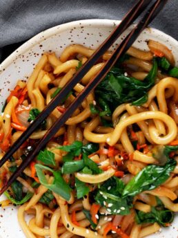 spicy udon noodles in bowl with chopsticks