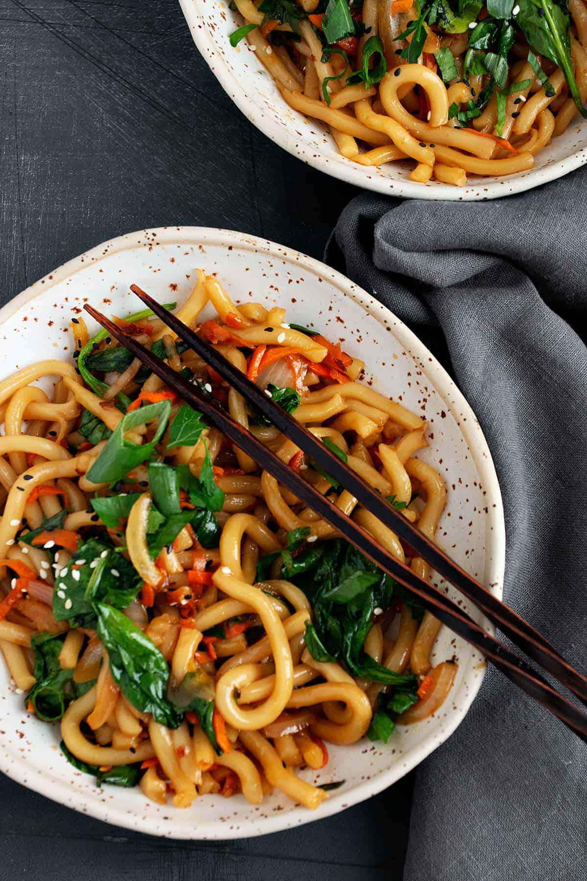 spicy udon noodles in bowl with chopsticks