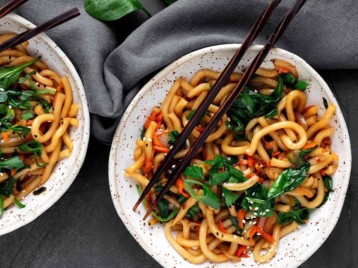 spicy udon noodles in bowl with chopsticks