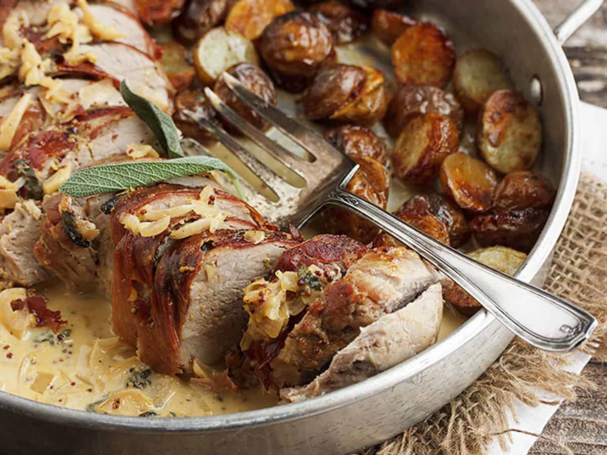 prosciutto wrapped pork tenderloin in pan with potatoes