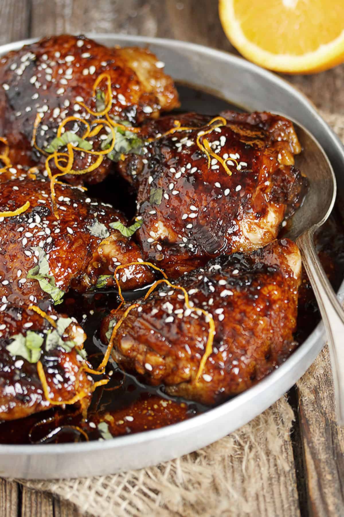 Asian sticky chicken in serving bowl with spoon