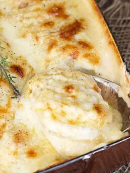 scalloped potatoes with bacon and cheese in casserole dish