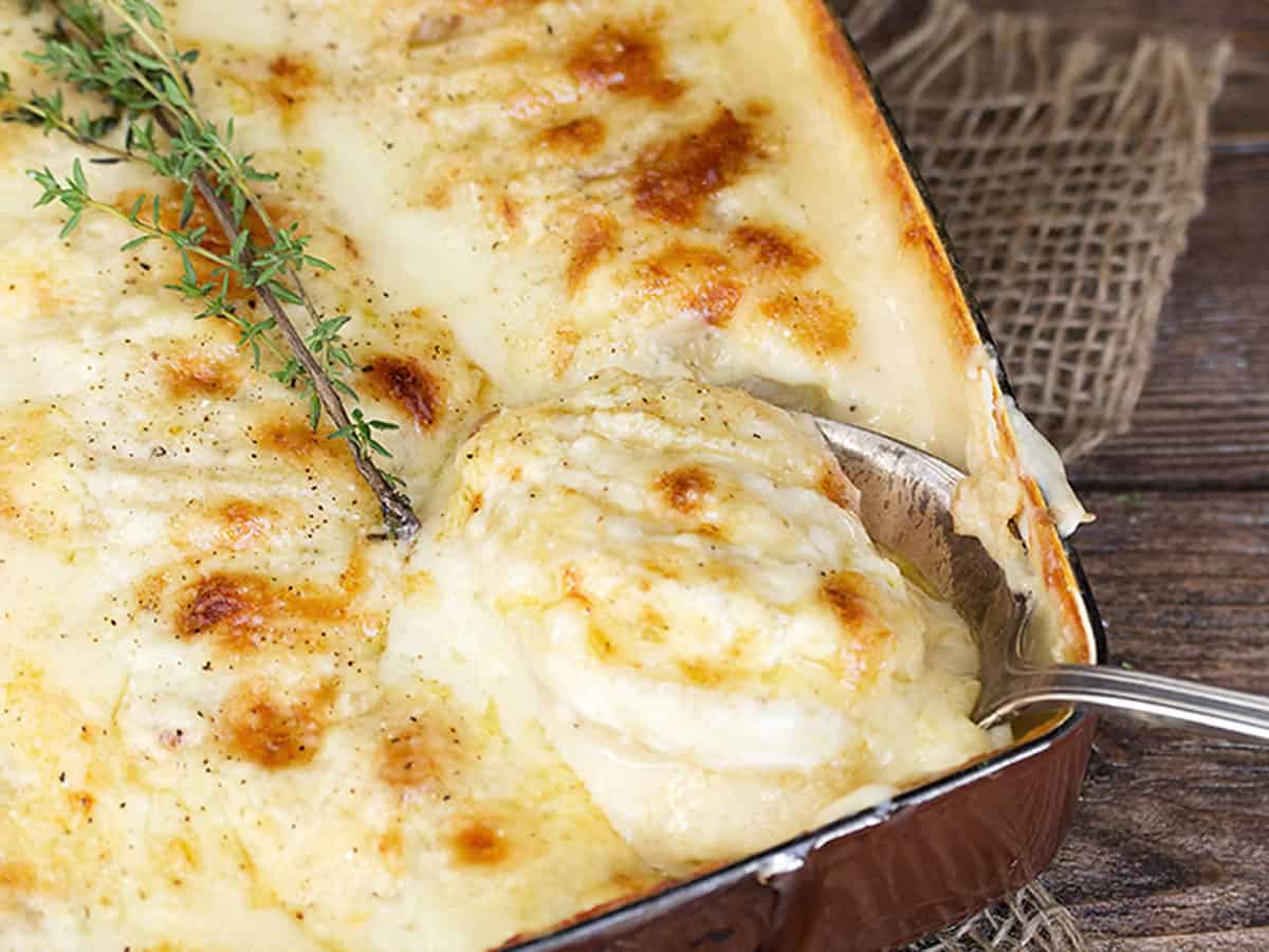 scalloped potatoes with bacon and cheese in casserole dish