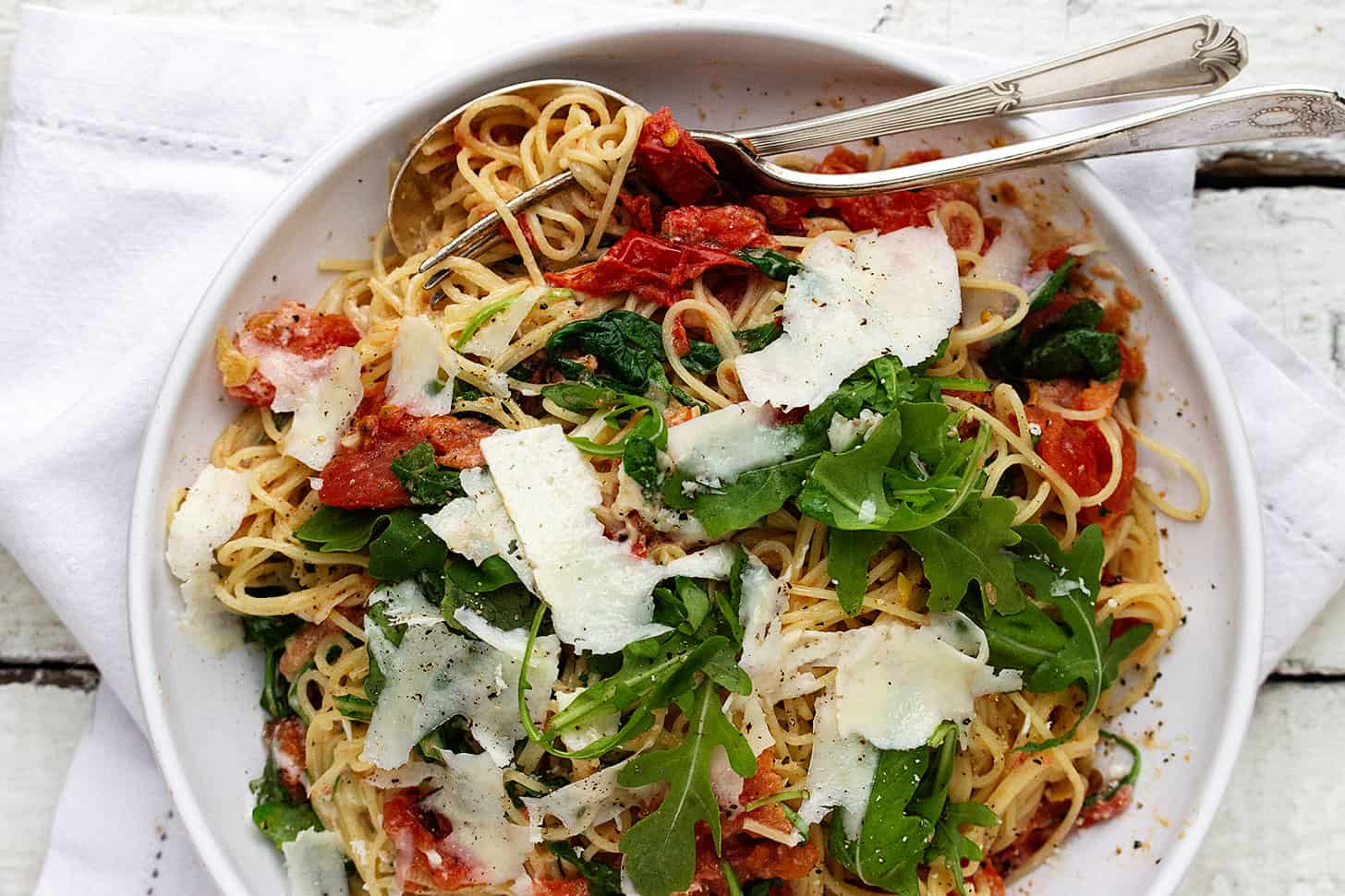 blistered tomato pasta in bowl with forks