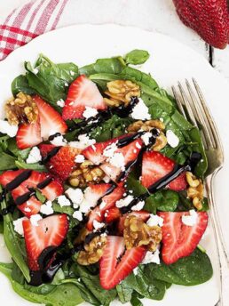 strawberry spinach salad on white plate