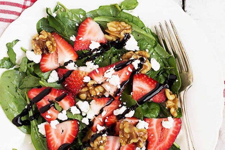 strawberry spinach salad on white plate
